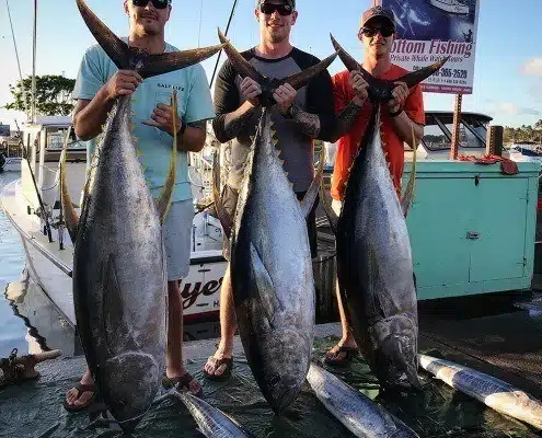 g3 Hawaii yellowfin charter Oahu, north shore. Fishermen standing with their catch next to the Flyer fishing boat in Haleiwa.