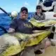 Oahu mahi mahi fishing charter showing off catch aboard the Flyer fishing vessel off the coast of Oahu's north shore.