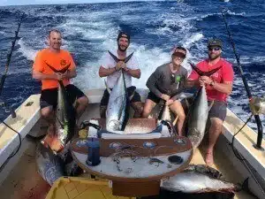 North Shore charter group taking a photo with their catch during a sportfishing trip.