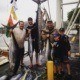 Marlin sport fishermen showing off their catch on the docks on the North Shore. Mahi-mahi and yellowfin tuna are also displayed.