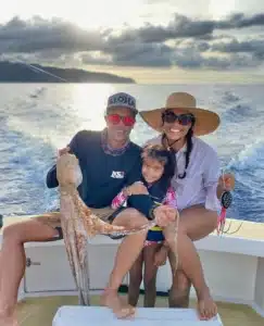 Oahu fishing charter, North Shore vacationers holding up an octopus.