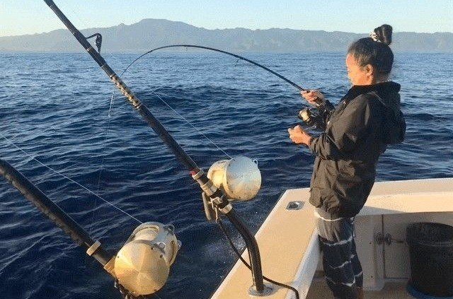 Reeling in skipjack tuna on Oahu aku charter in Hawaii.