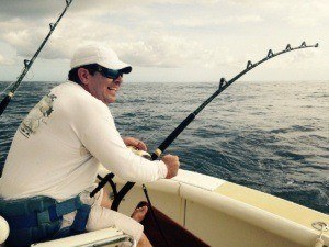 Fisherman on a Hawaii fishing tour attempting to catch a blue marlin.