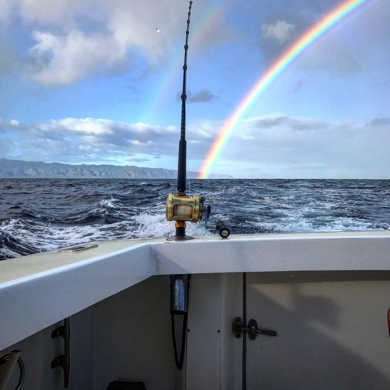 Rainbow over the pacific ocean during a fishing charter near North Shore, Oahu, Hawaii.