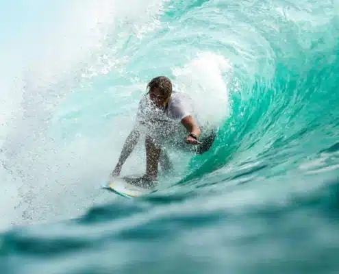 Man surfing in wave on North Shore. Flyer Sportfishing offers North Shore fishing charters on Oahu North Shore